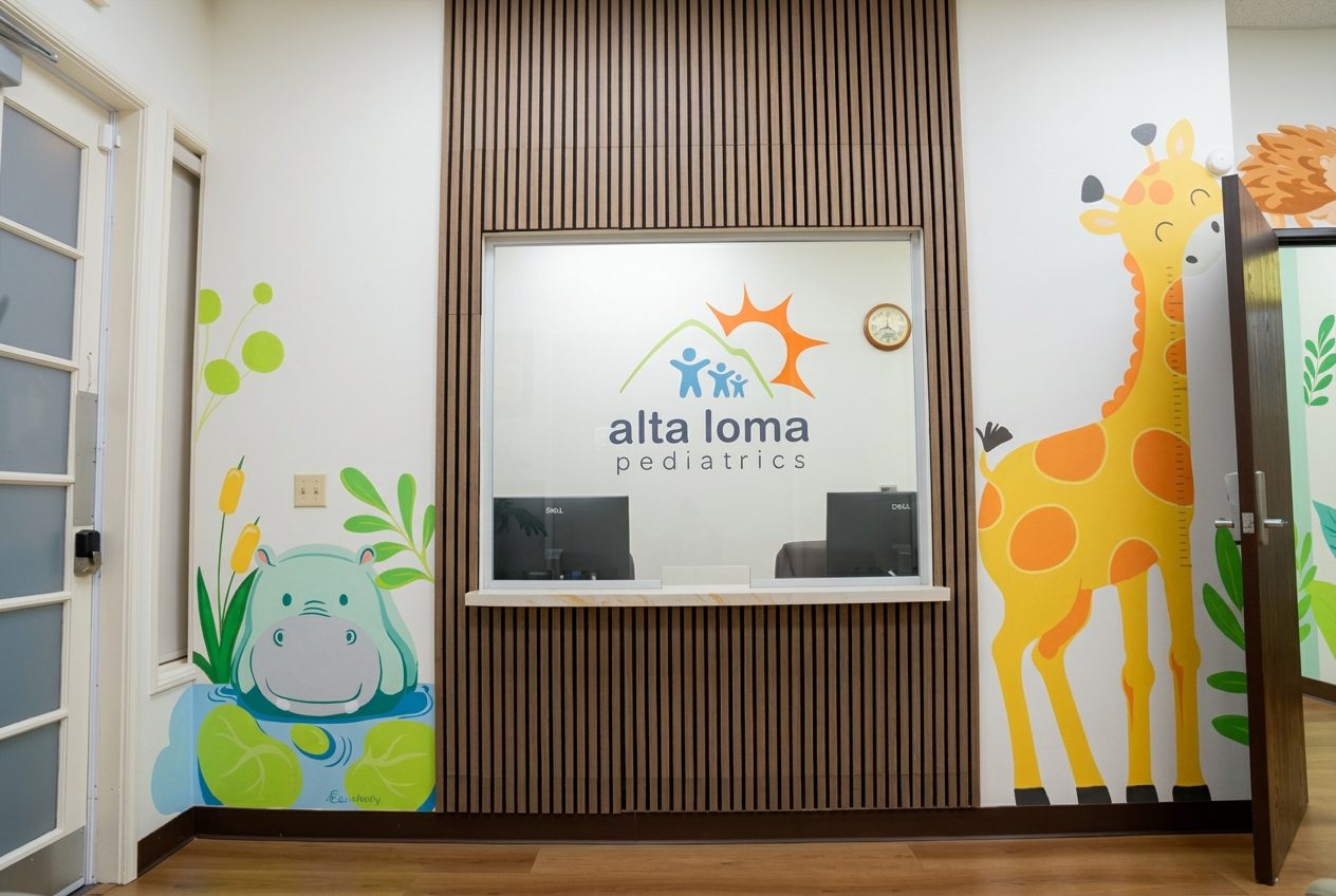 Front desk check-in window at Alta Loma Pediatrics with hippo and giraffe wall murals