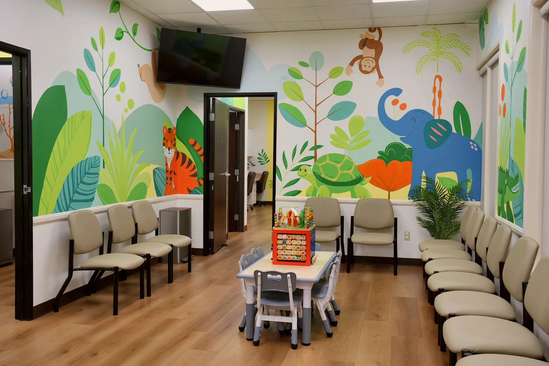 Colorful jungle-themed waiting room with kids’ play table at Alta Loma Pediatrics in Rancho Cucamonga